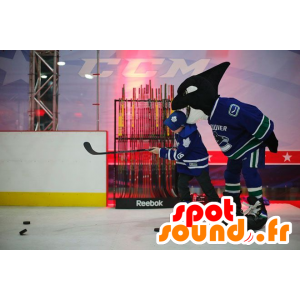 Svart och vit späckhuggarmaskot, i hockeyklädsel - Spotsound