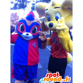 2 mascottes : un ours jaune et un animal masqué, bleu et rouge - MASFR20737 - Mascotte d'ours