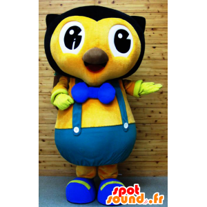 Svart och gul uggelmaskot, i blå overall - Spotsound maskot