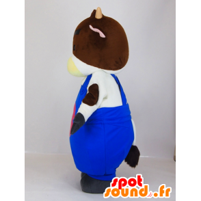 Maskot vit och brun ko i blå overall - Spotsound maskot