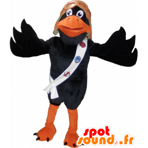 Svart och orange kråka maskot med en pilothjälm - Spotsound